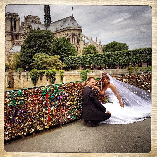 Newlyweds-installing-their-love-locks-on-the-bridge-behind-the-Notre-Dame6